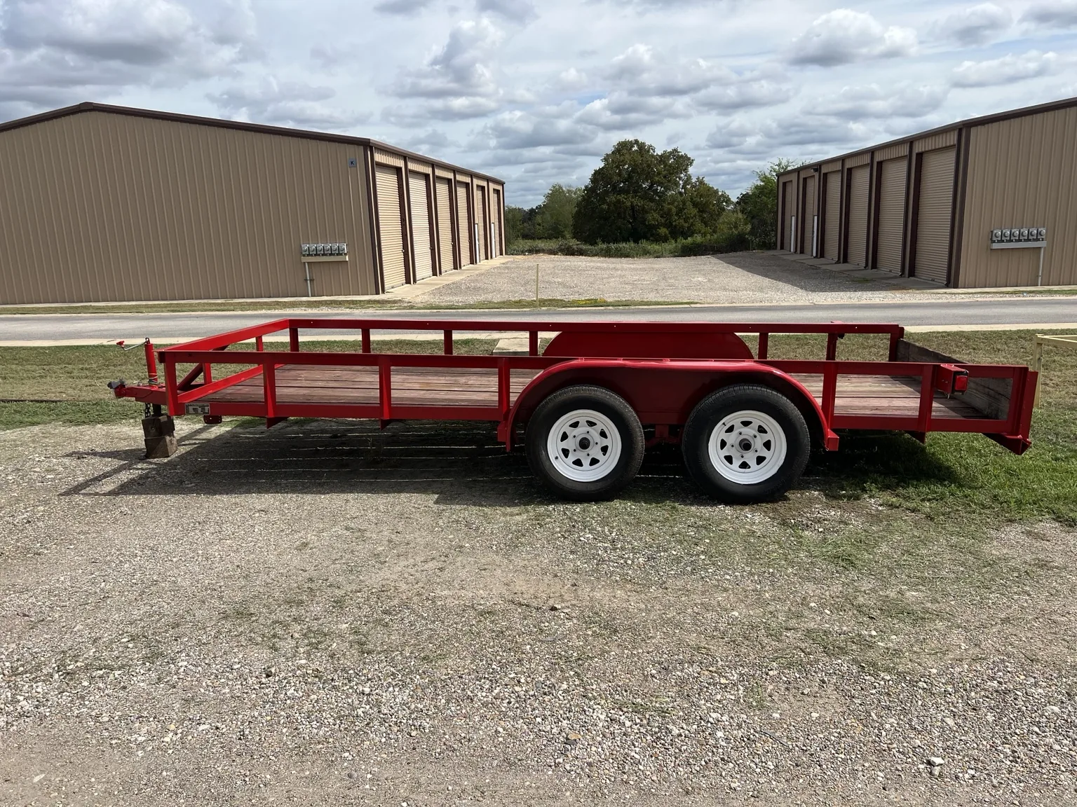 Red steel utility trailer with welded frame and tandem axle